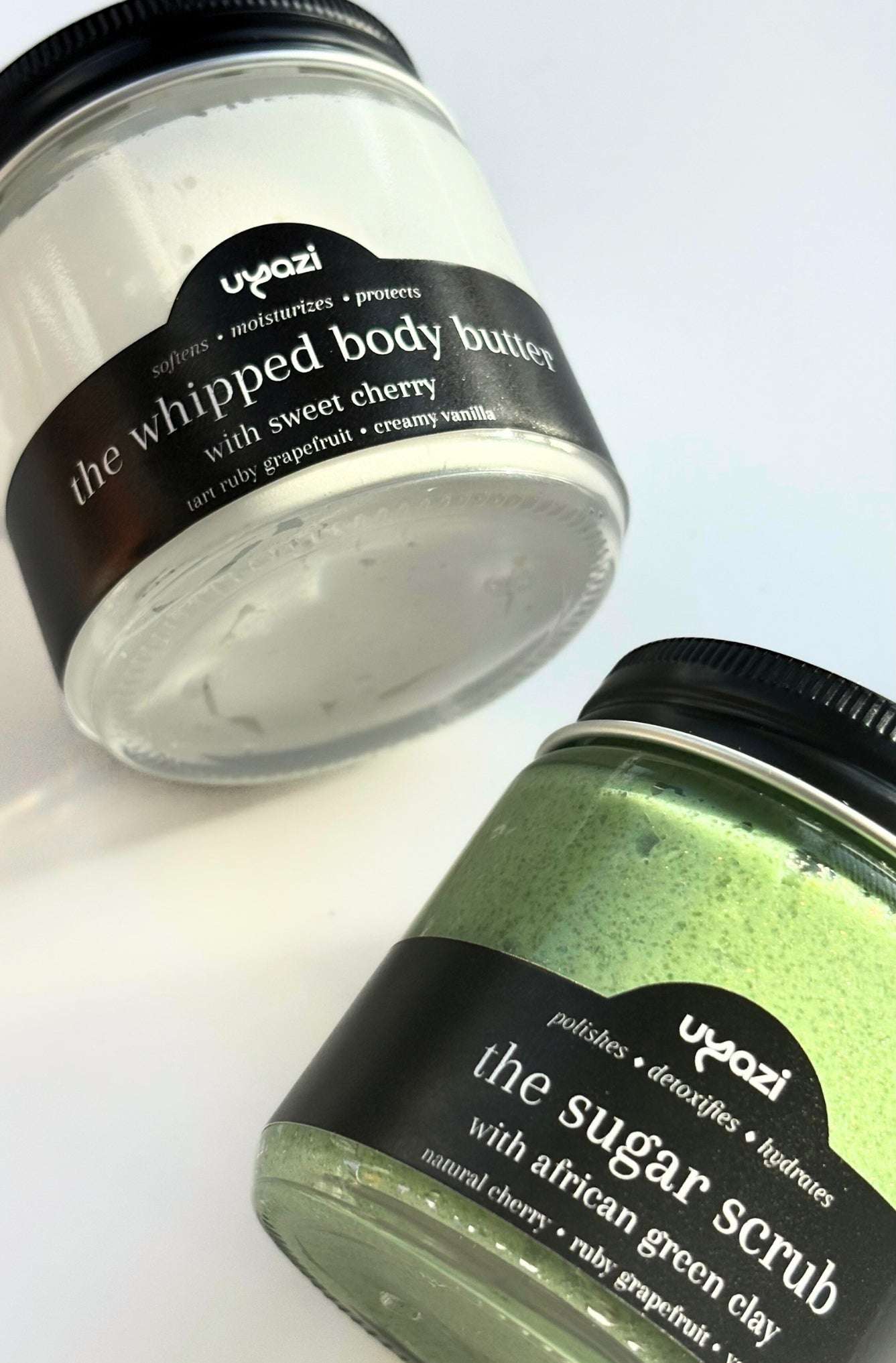 Two jars of Uyazi body care products on a white background