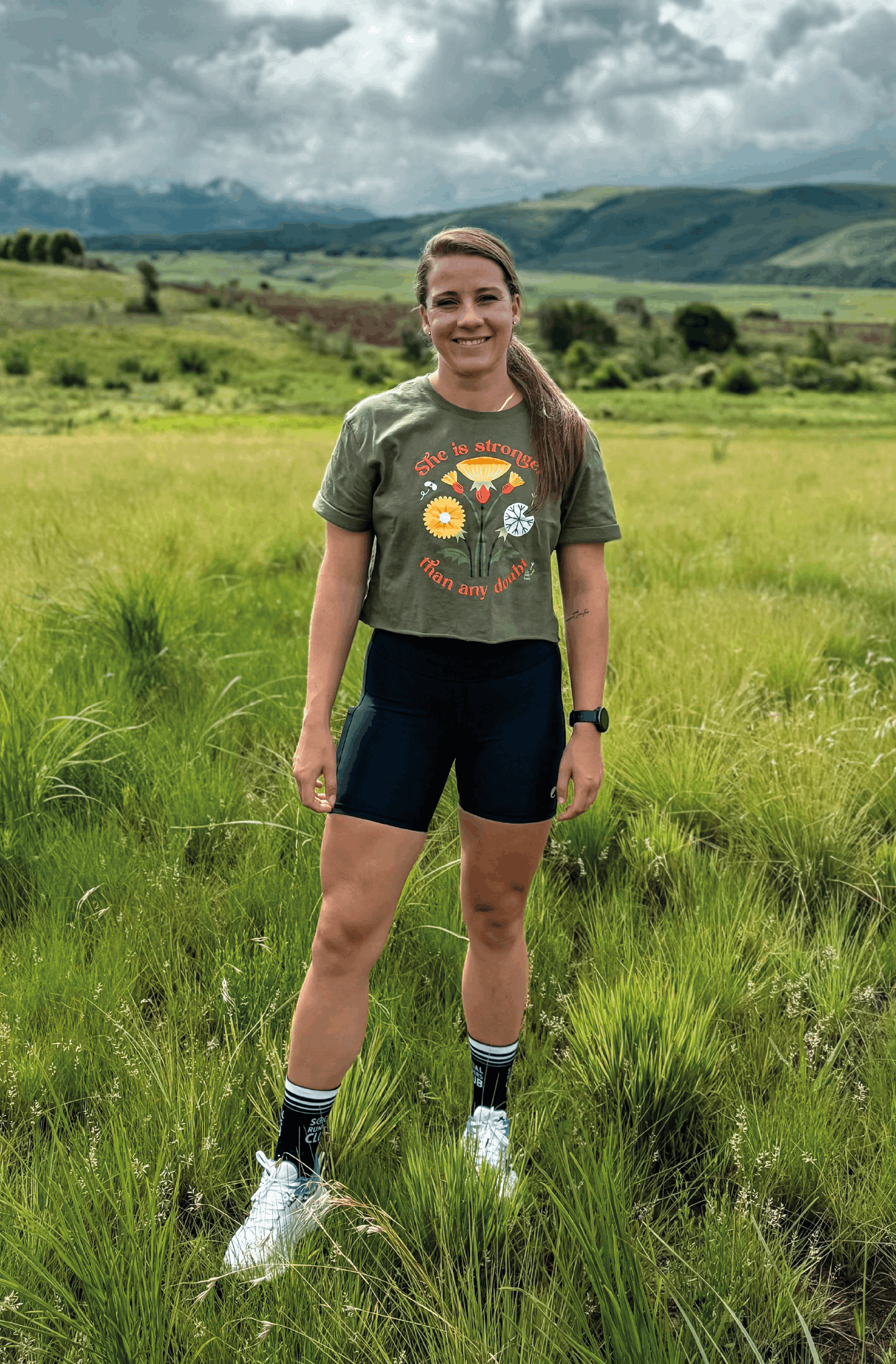 Braver woman wears a crop top with "she is stronger" design in the front