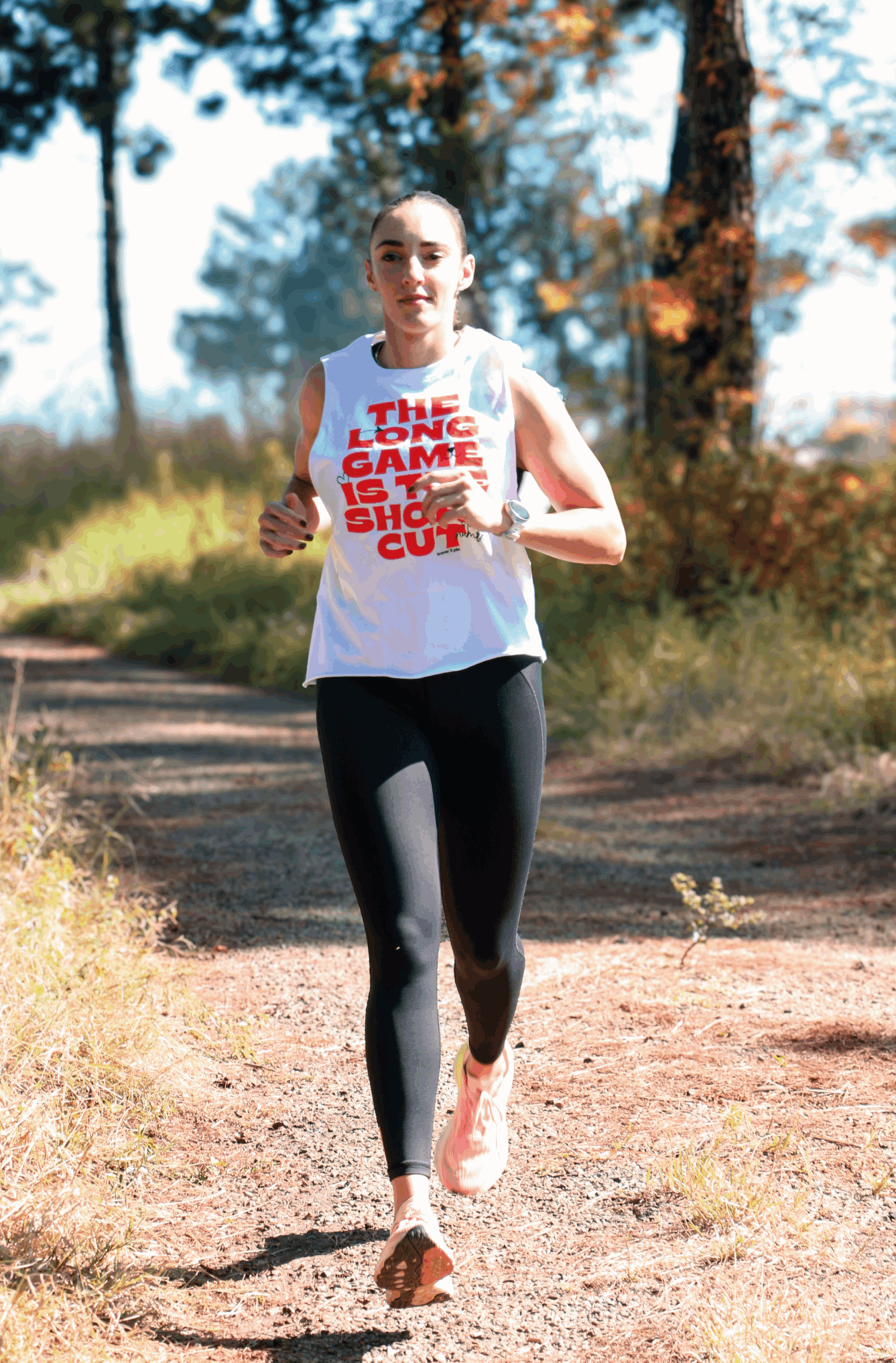 Womens Training Sleeveless white tank top with typographic orange print - running along a trail