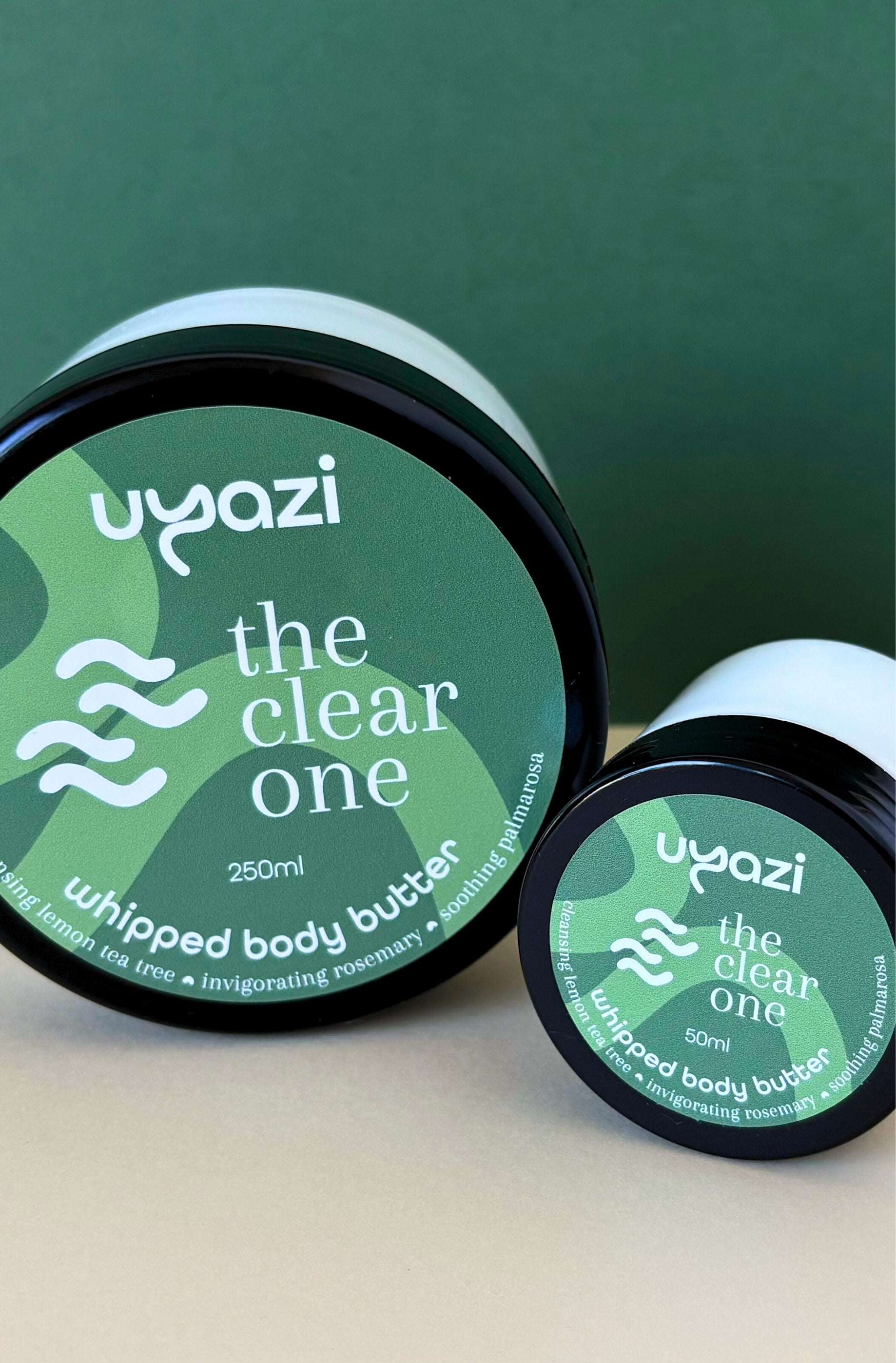 Two containers of Uyazi 'the clear one' whipped body butter on a green background