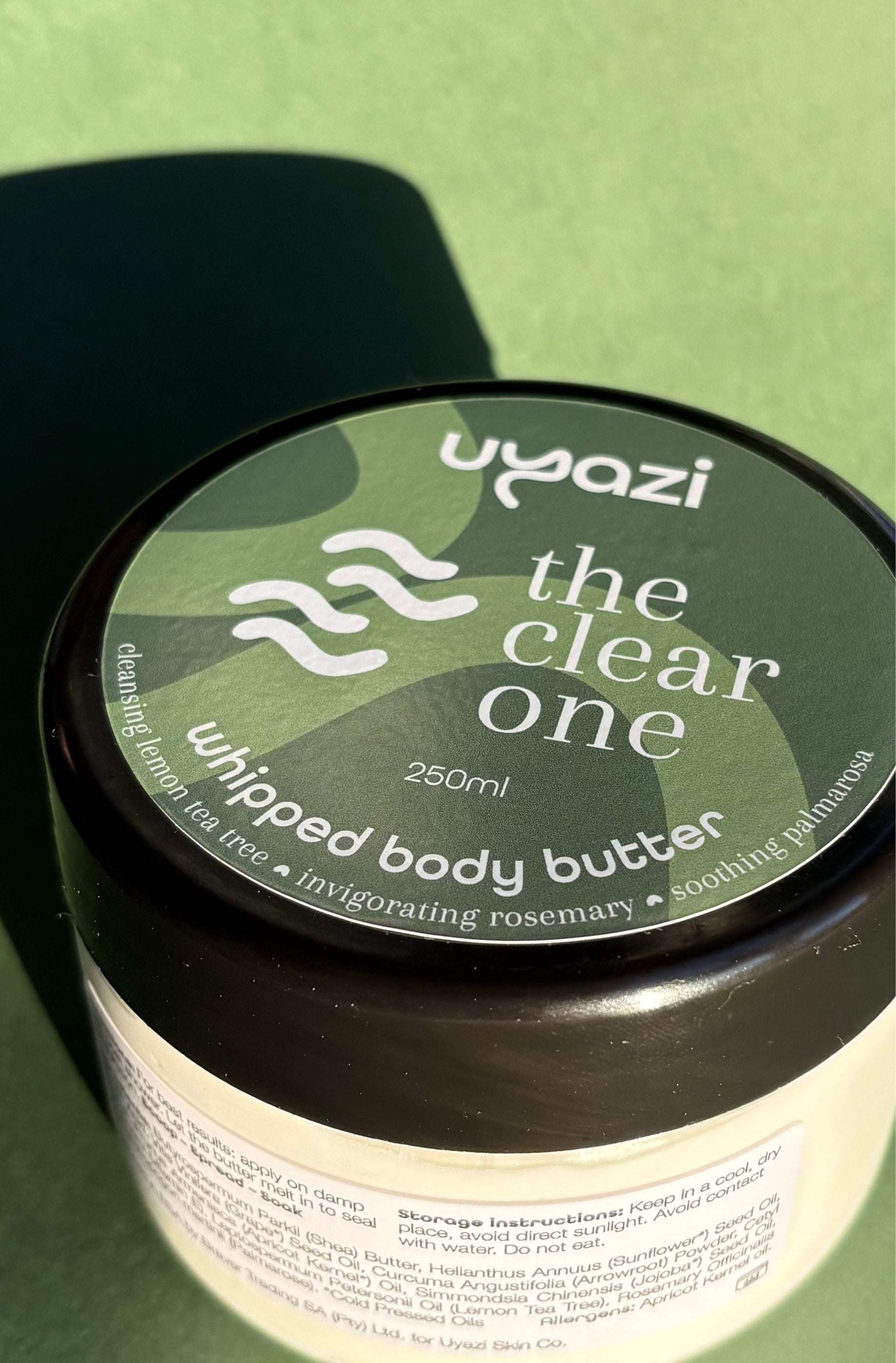Uyazi whipped body butter container with green label on a green background