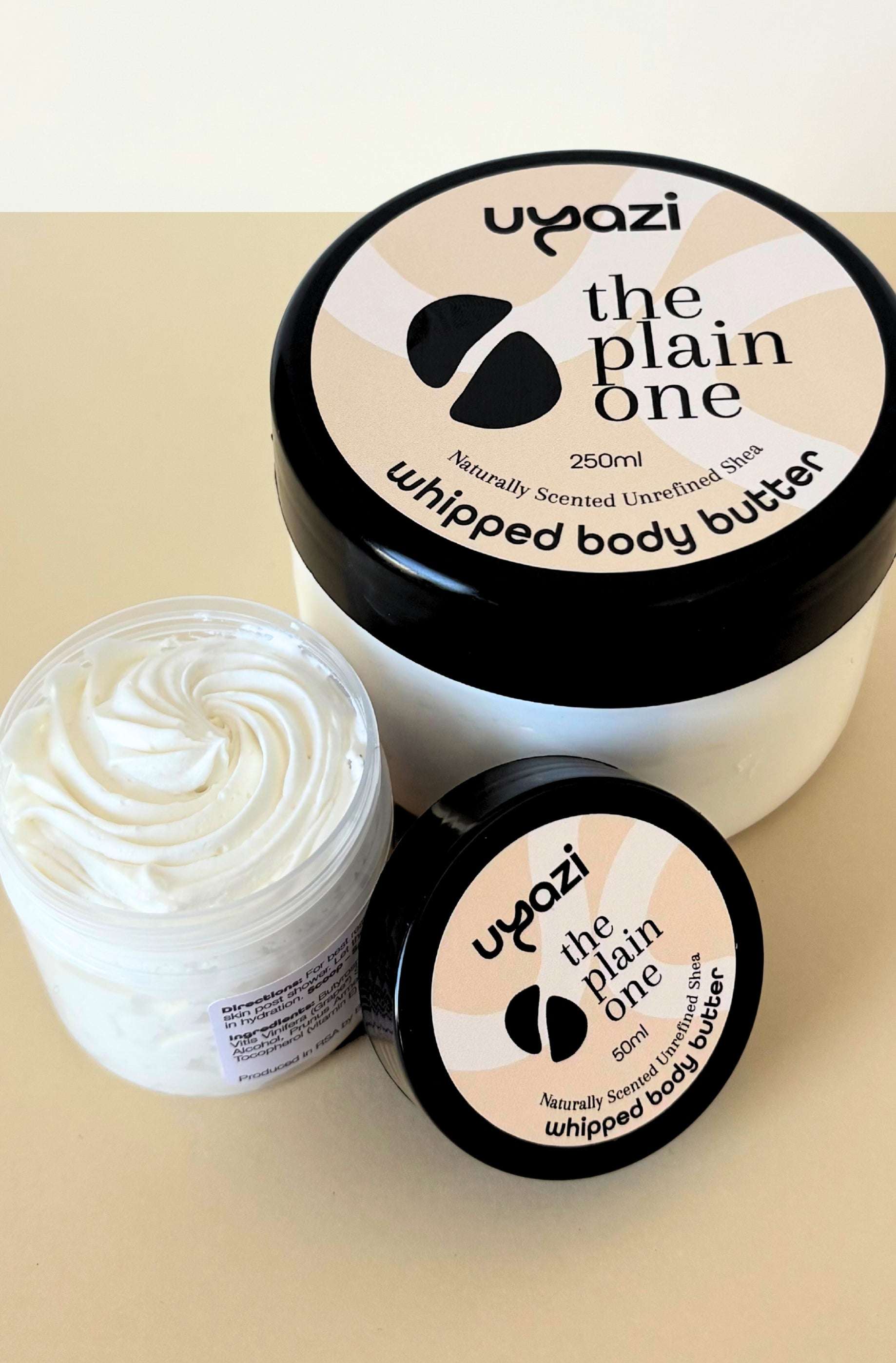Two containers of Uyazi 'the plain one' whipped body butter on a beige background
