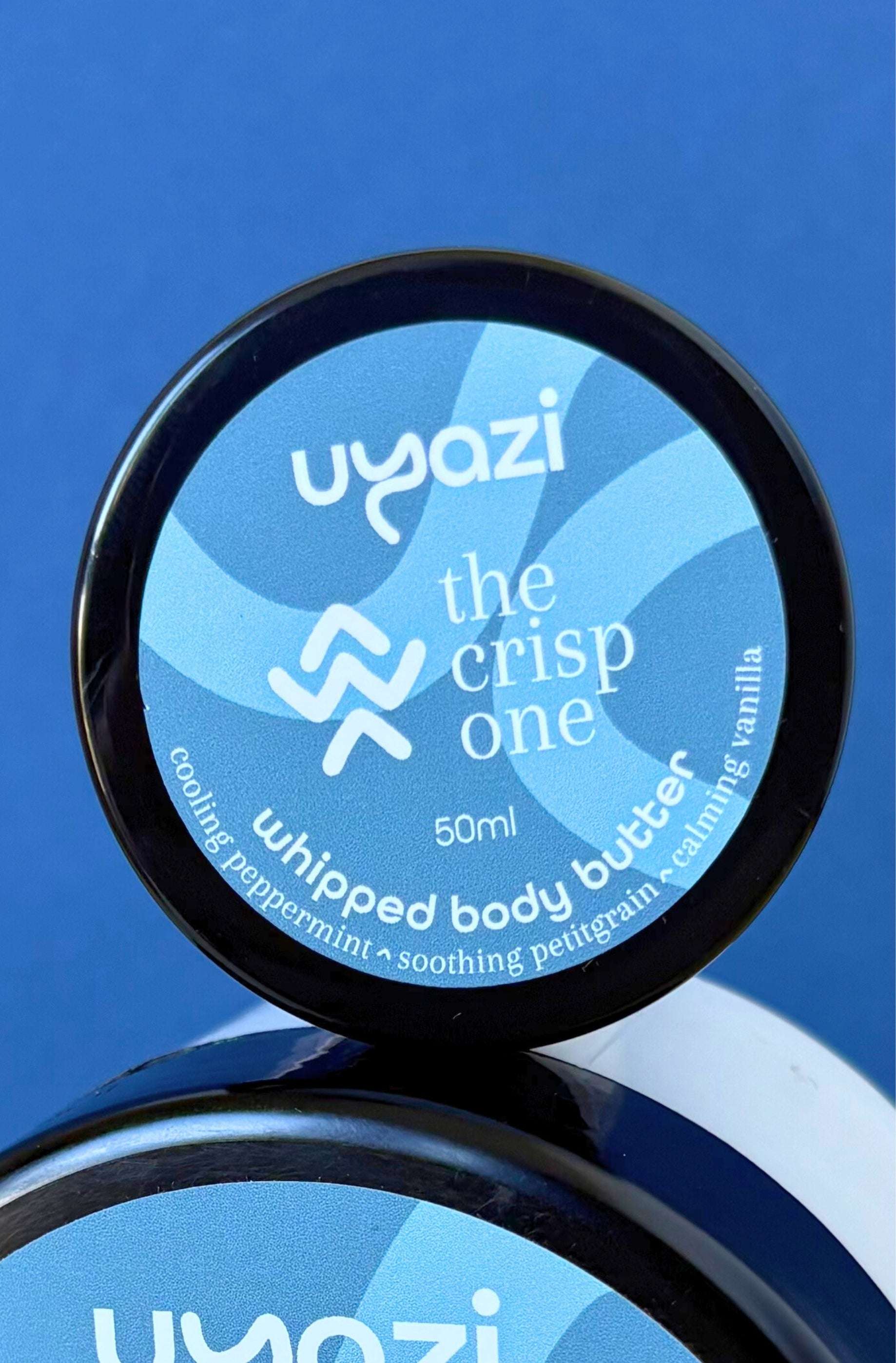 Uyazi whipped body butter container with blue label on a blue background
