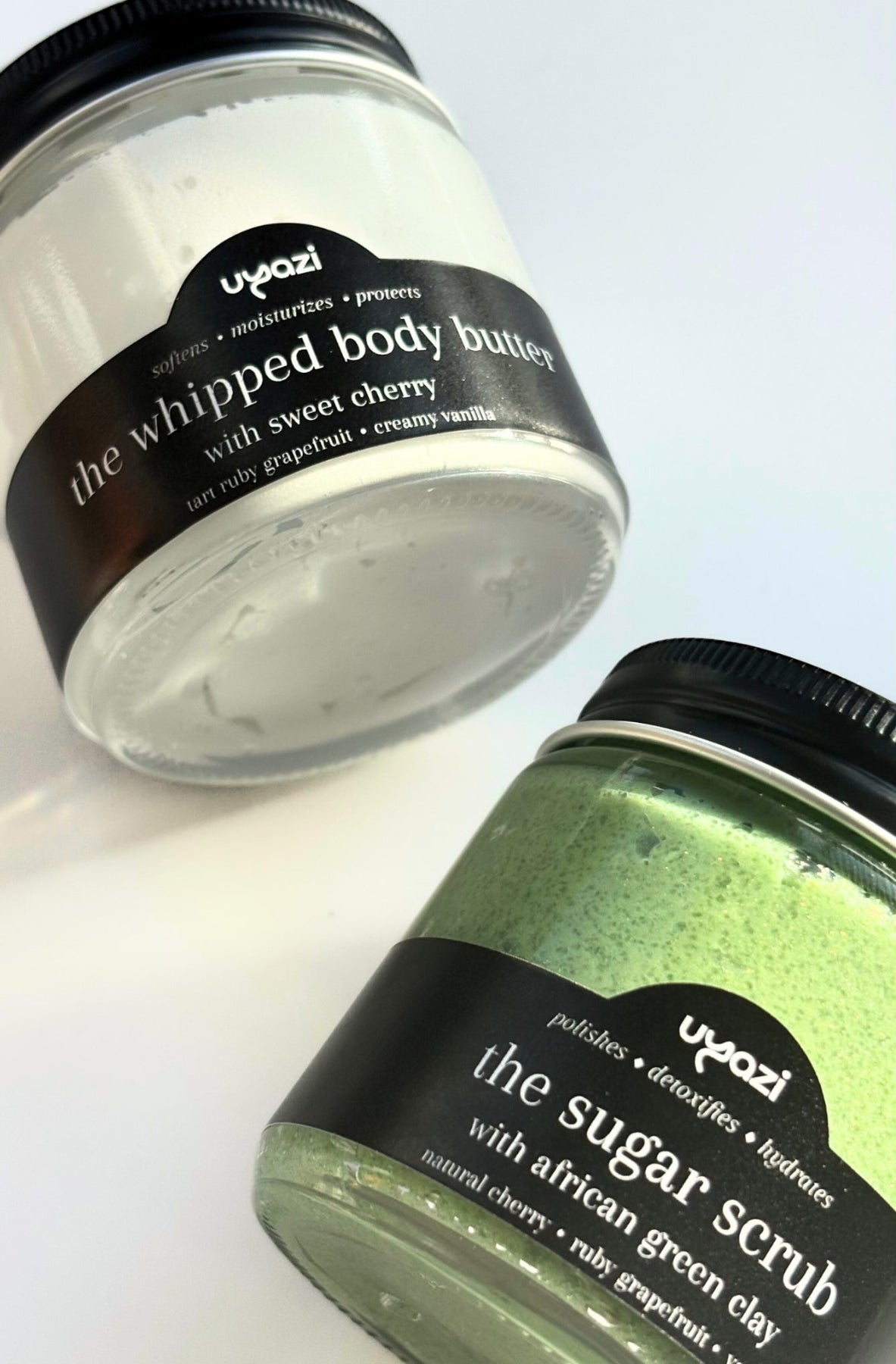 Two jars of Uyazi body care products on a white background