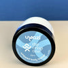 Uyazi whipped body butter jar on a beige surface with a blue background