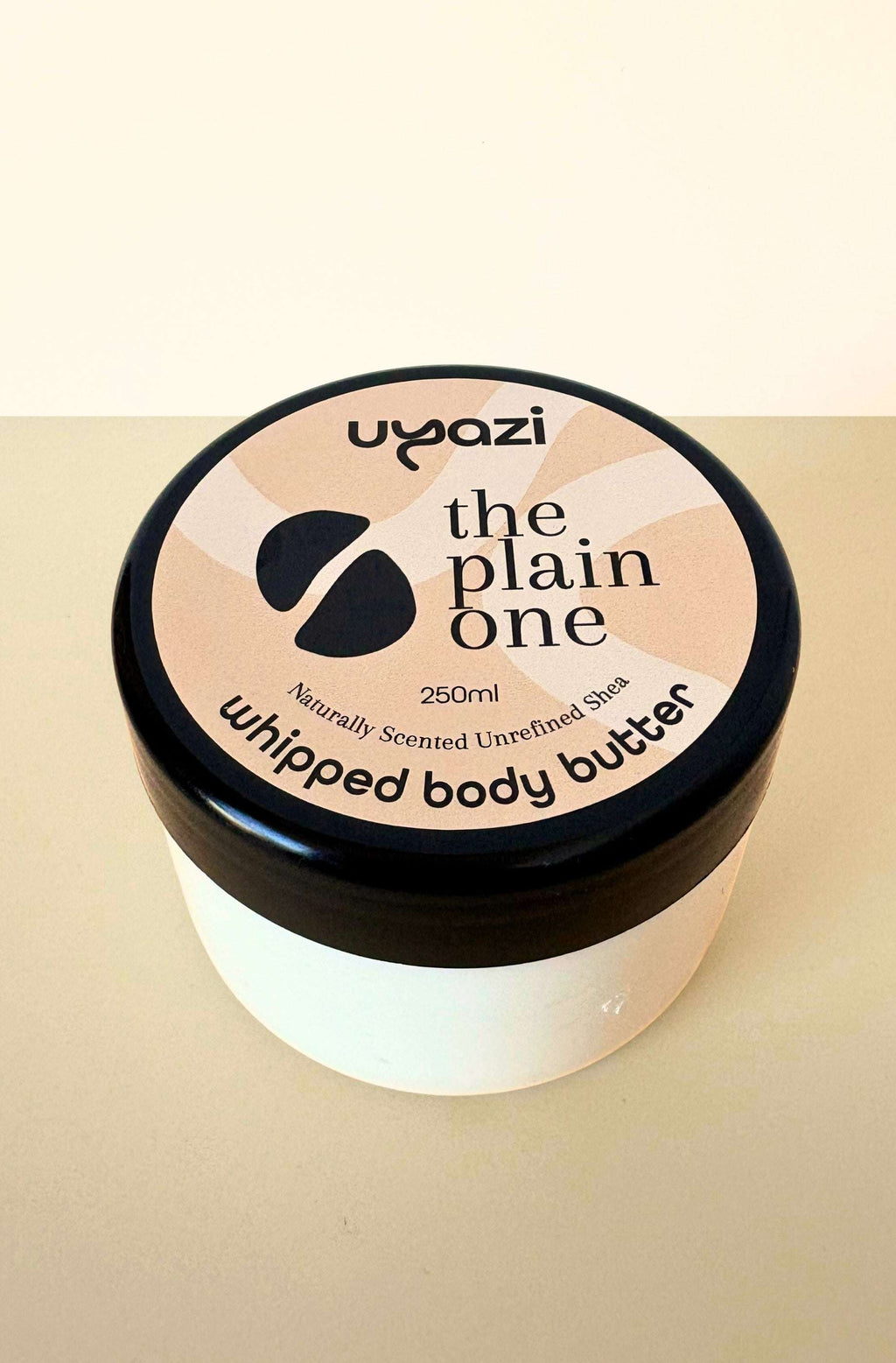 Uyazi naturally scented whipped body butter jar on a beige background