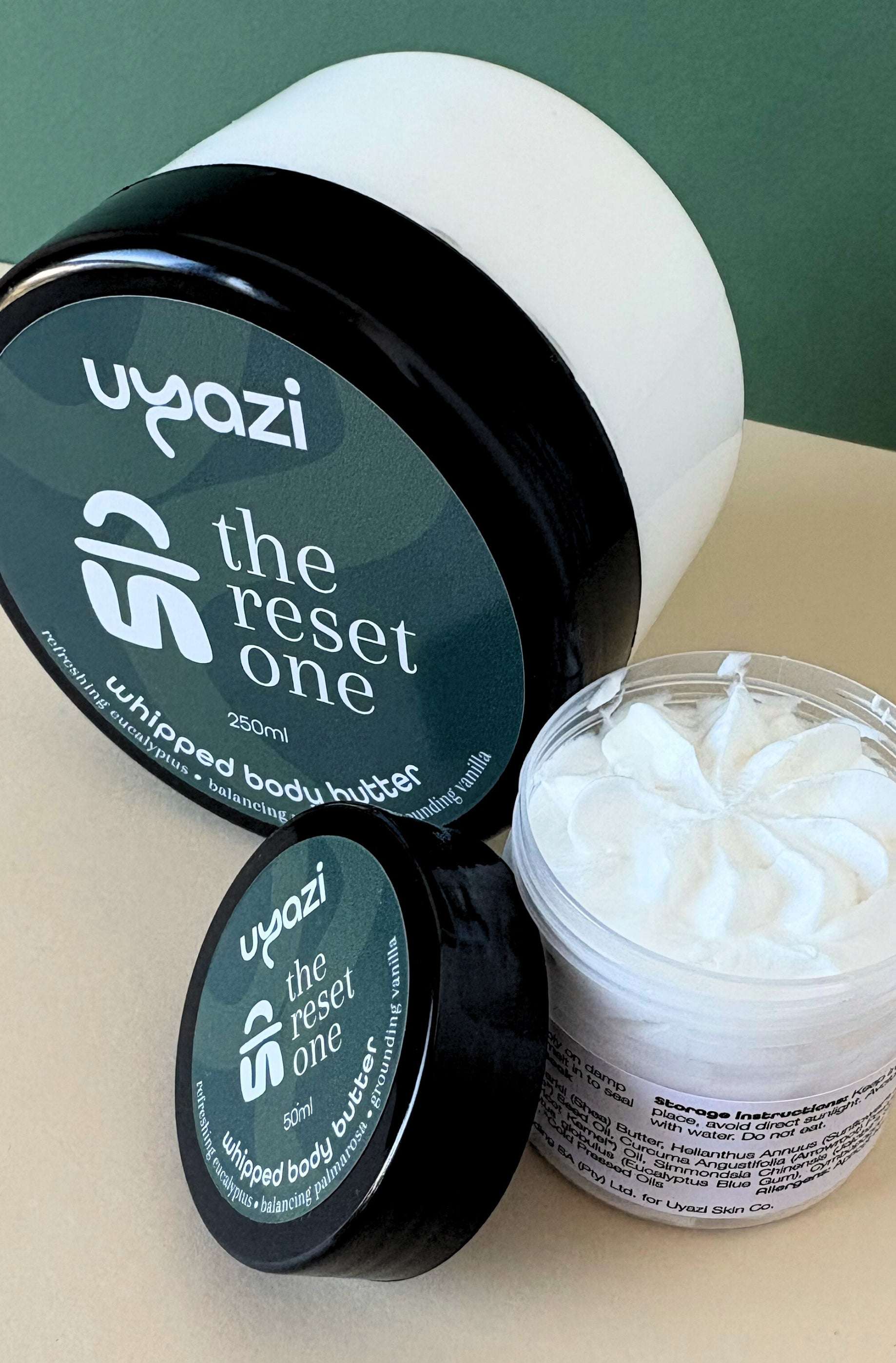 Uyazi whipped body butter jar with open lid on a light surface