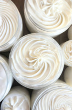 Close-up of containers filled with white whipped body butter
